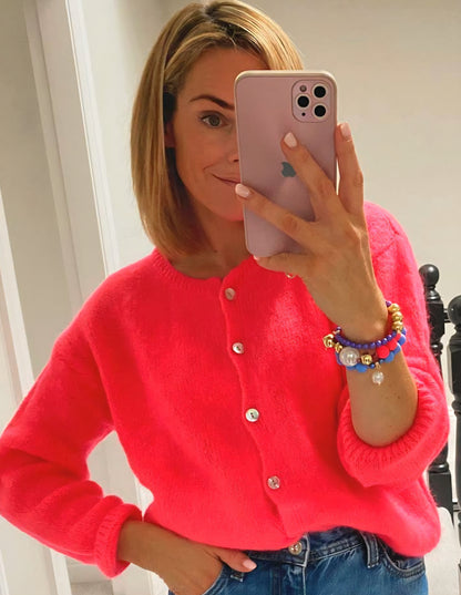 Woman wearing a bright Neon Coral Superfine alpaca cardigan.